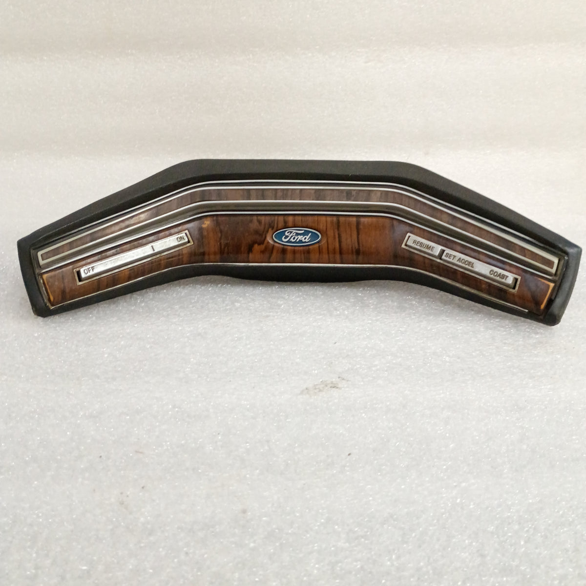 Ford wood grain steering wheel horn pad with cruise control buttons for Off, On, Resume, Set/Accelerate, and Coast.