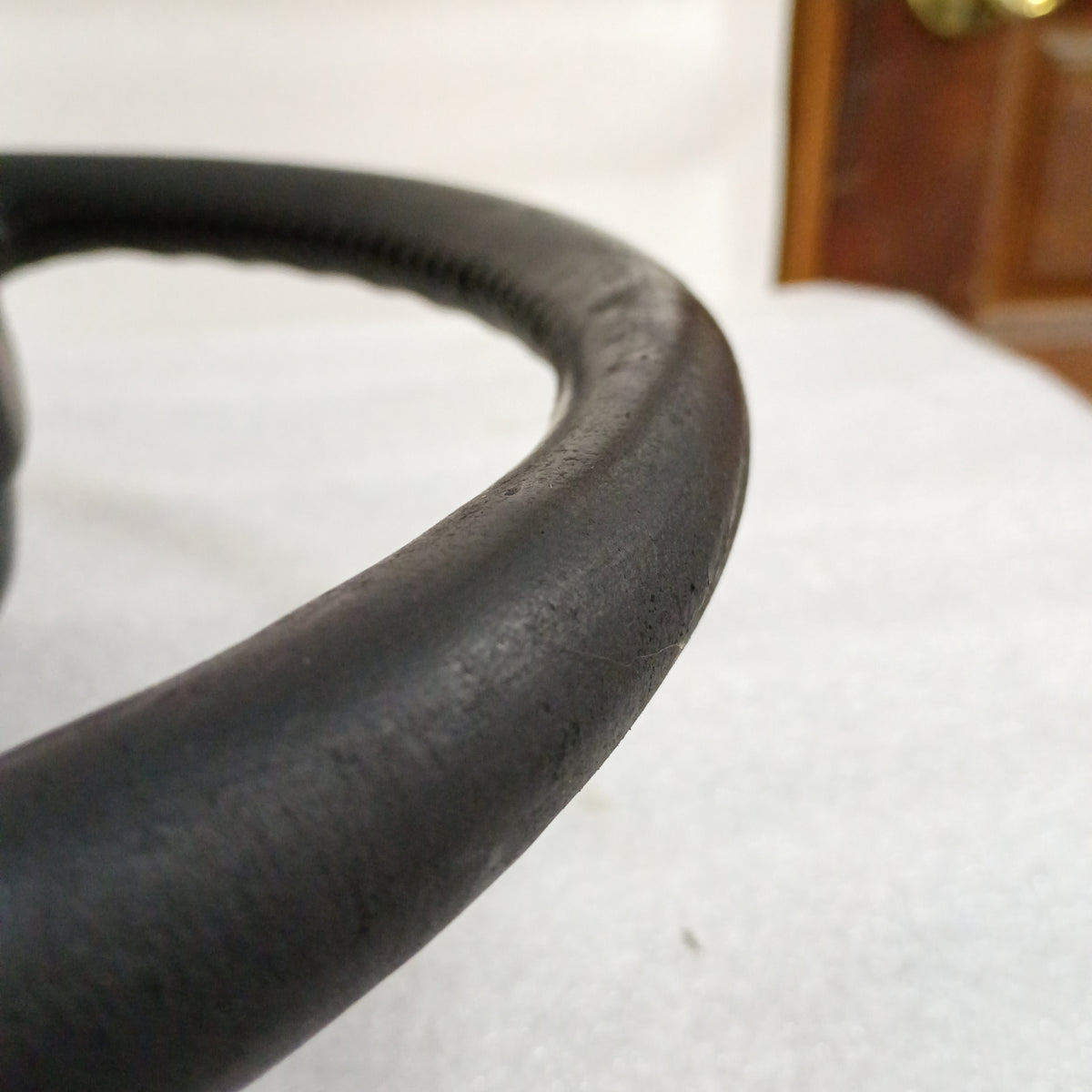 Close-up of a black leather steering wheel edge with visible stitching, suitable for 1987-1991 Ford trucks and Bronco.