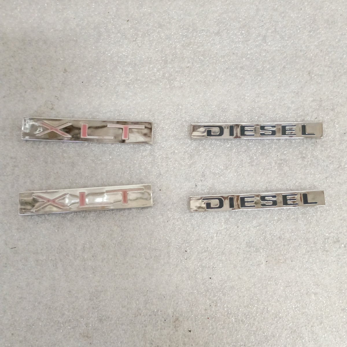 Ford XLT and Diesel emblems set for 1983-1991 F150, F250, F350, and Bronco. Genuine OEM with wear, requires new adhesive.