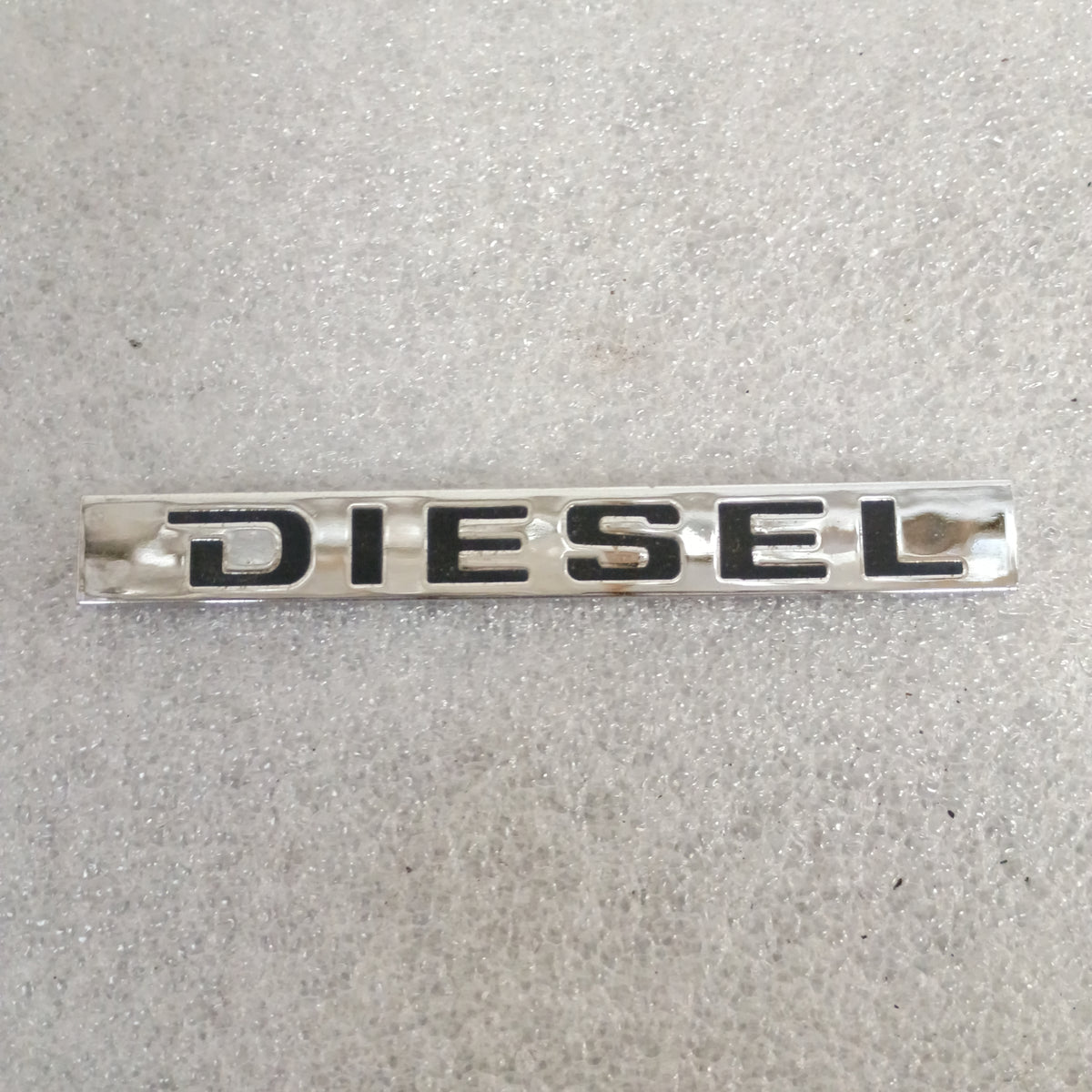 Chrome "DIESEL" emblem with black lettering; part of a Ford emblem set for 1983-1991 F150, F250, F350, and Bronco.