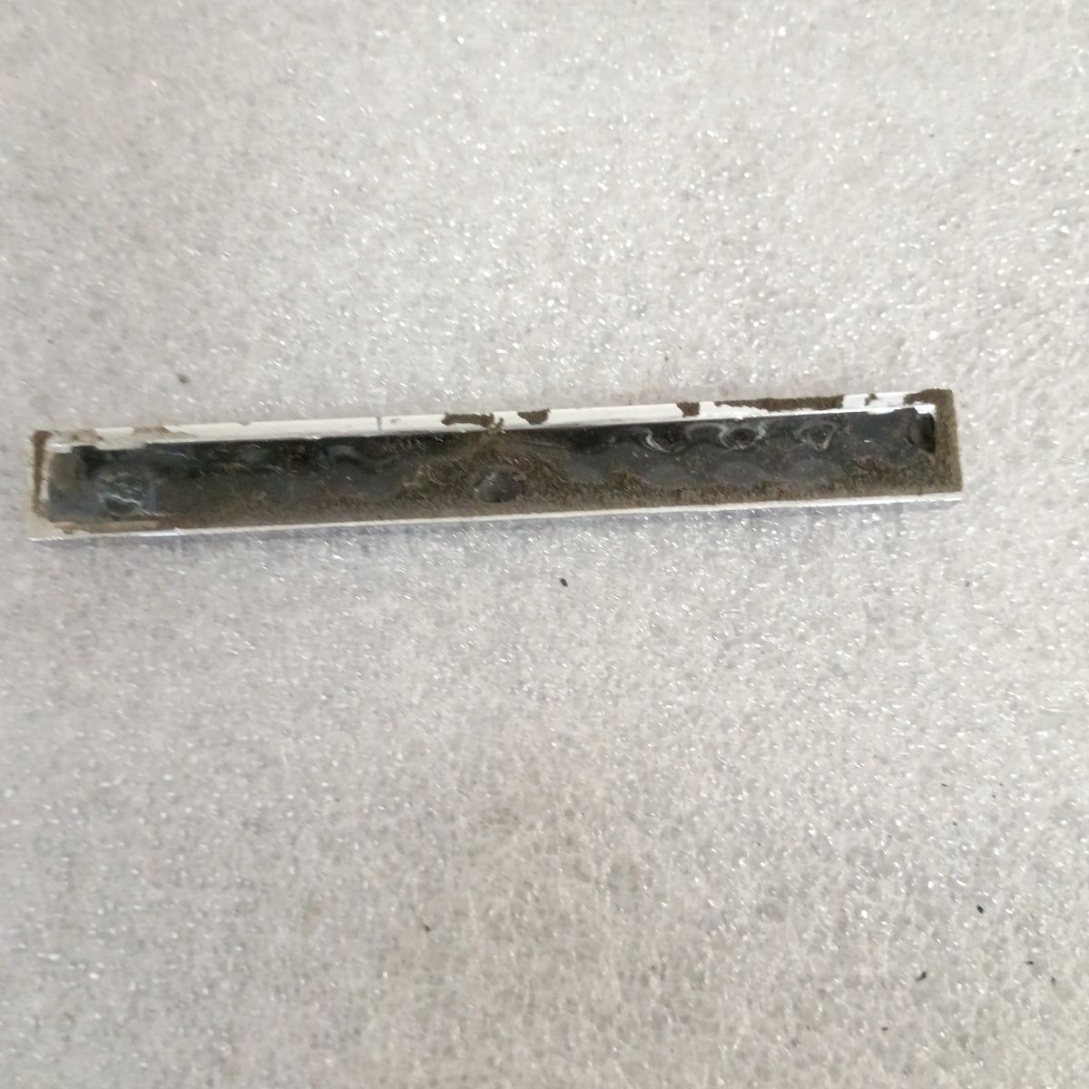 Backside of a used Ford Diesel emblem from the 1983-1991 F-Series trucks, showing wear and missing mounting nipples.