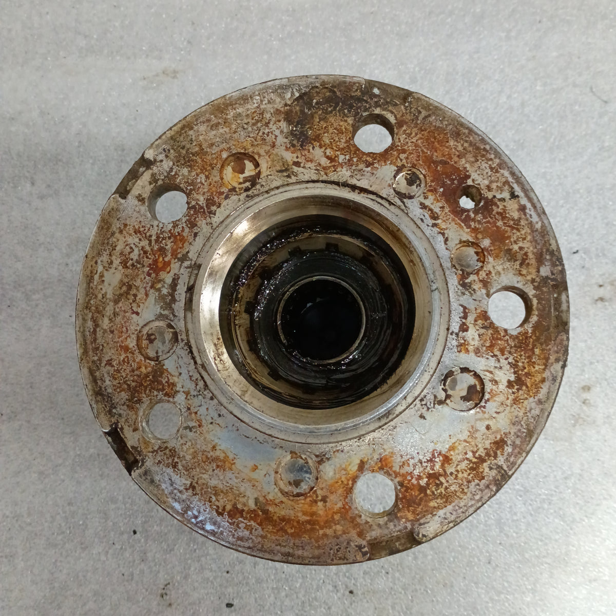 Rusty top view of a 1987-1988 Ford F-150/Bronco manual locking hub with bolt holes, suitable for Dana 44 IFS.