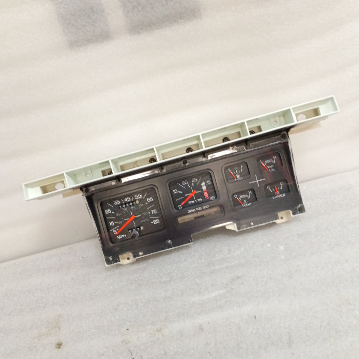 Refurbished 1980-86 Ford truck gauge cluster with tachometer, new lens, and tested gauges on white background.