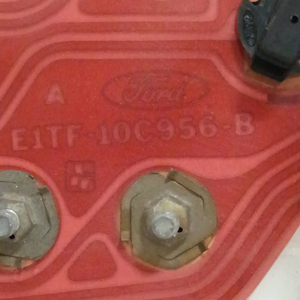 Close-up of a refurbished Ford gauge cluster part with model number E1TF-10C956-B embossed on a red panel.