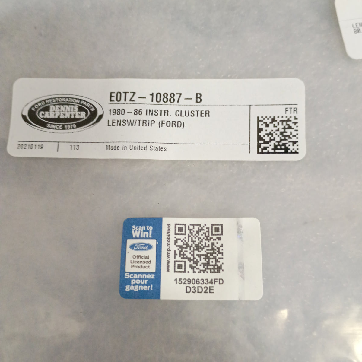 Sticker labels showing Dennis Carpenter Ford restoration part number and QR code on a 1980-86 Ford instrument cluster.