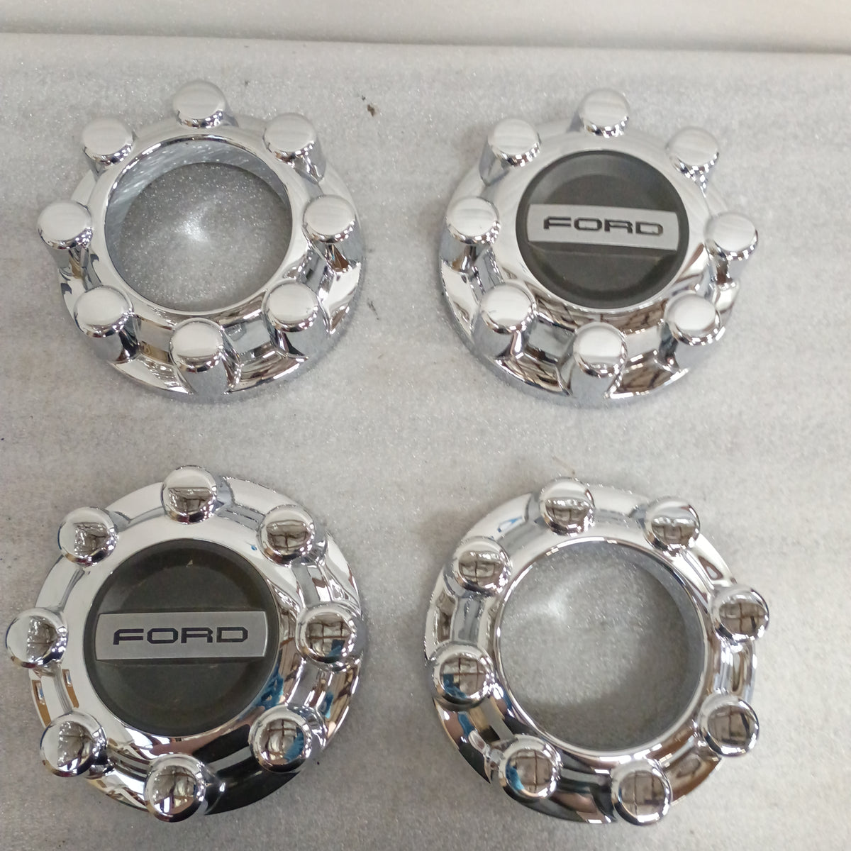 Set of four chrome Ford wheel center caps, two closed and two open, 8 3/8" diameter, compatible with 2017-2023 F250/F350.