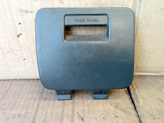 Dark gray fuse panel cover for 1992-1996 Ford F-Series and Bronco, marked "Fuse Panel," mounts under dash.