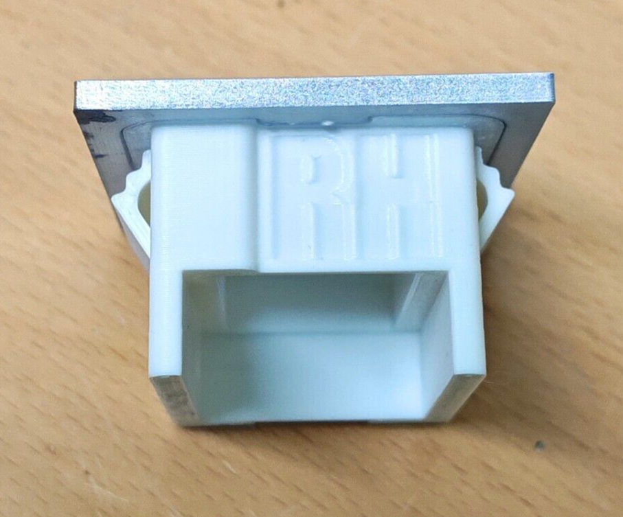 Rear view of the passenger side power window bezel for 1980-1986 Ford F-Series and Bronco, showing the white polymer switch housing with molded RH lettering and side mounting clips.