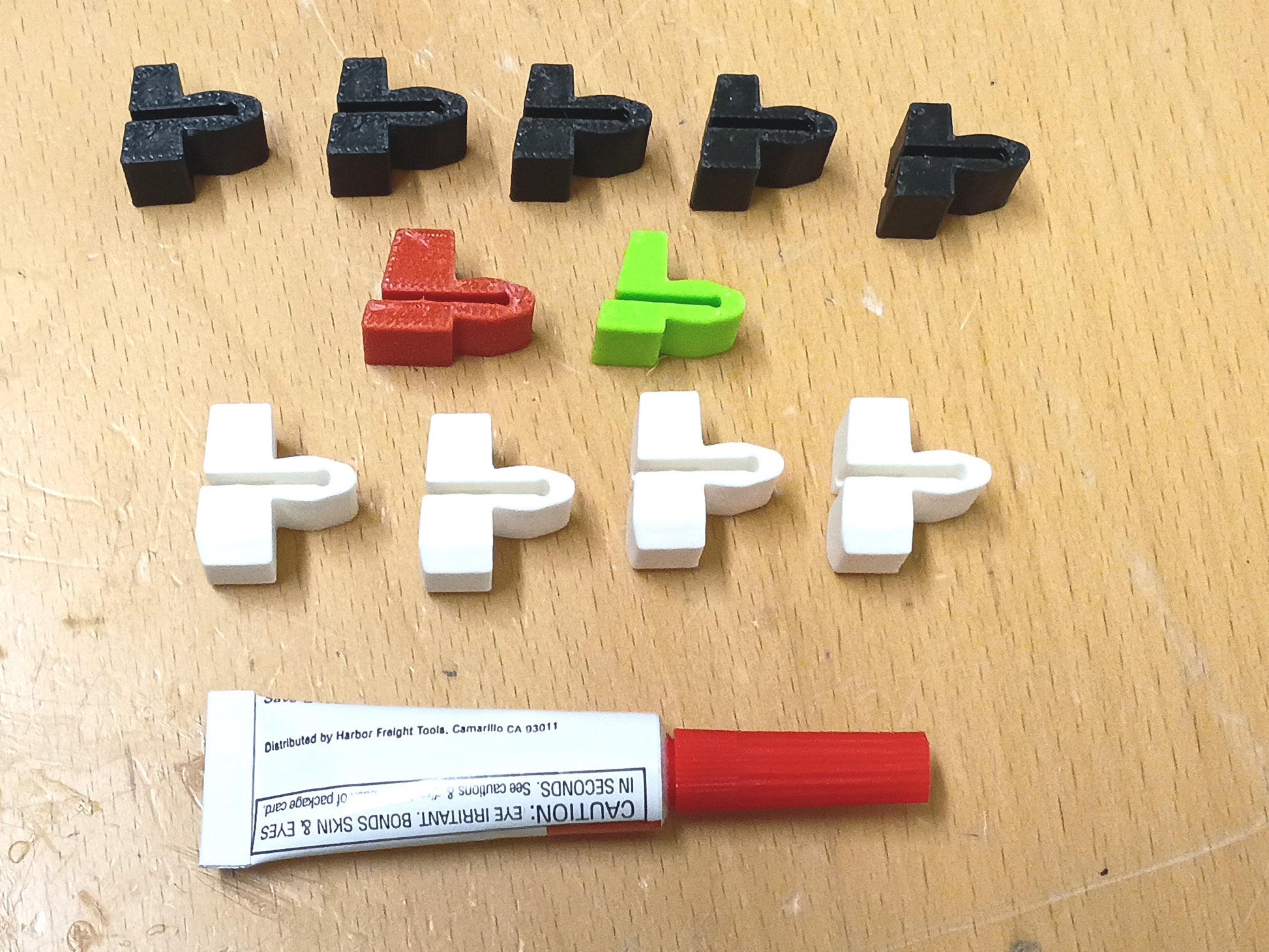 Blue Truck Parts Dash Trim Strip Repair Kit featuring ten T-shaped plastic repair clips in black, red, green, and white, alongside a tube of adhesive glue.