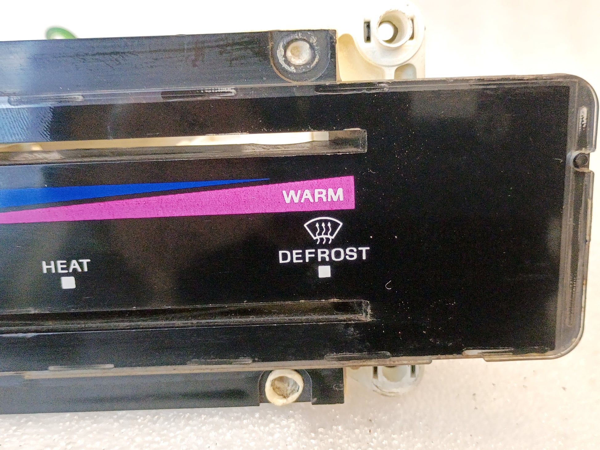 Ford heater and AC control panel with colored temperature indicators, labeled "Warm," "Heat," and "Defrost."