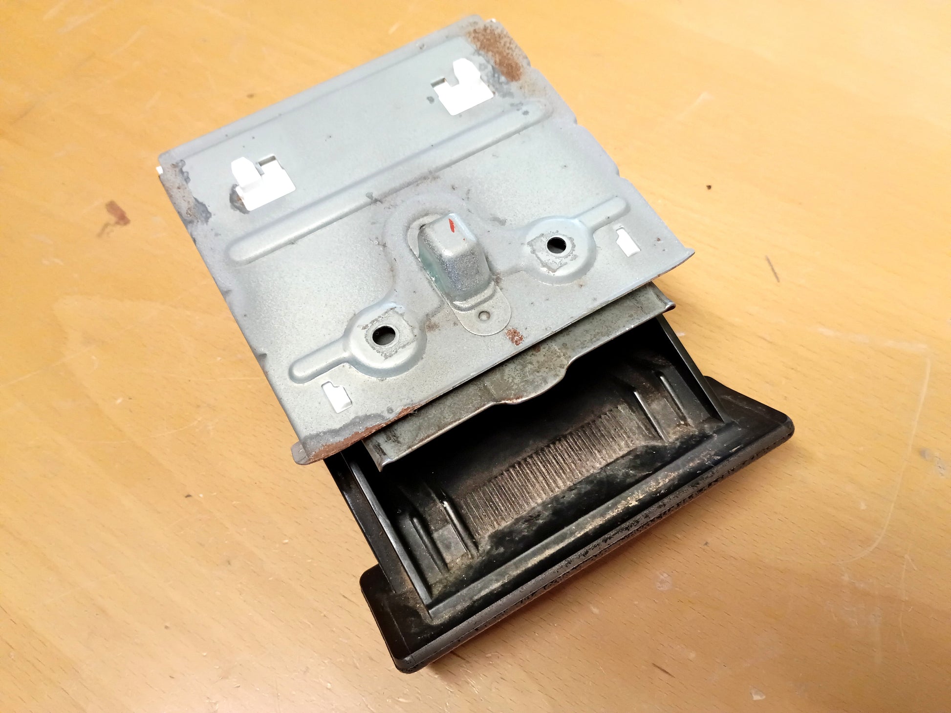 Ashtray guide set for Toyota Pickup, 4Runner, Tacoma; silver metal bracket with snap-in guides on a wooden surface.