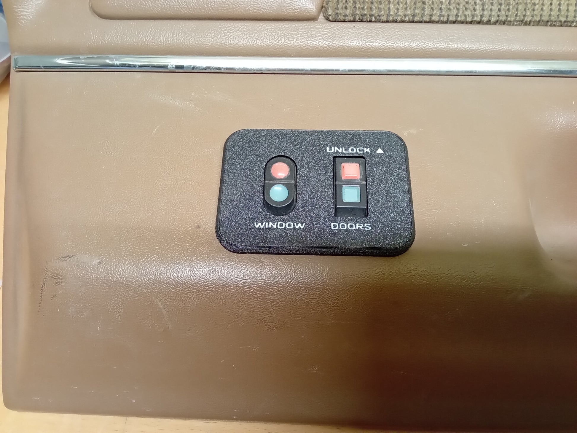 Ford power window and lock bezel for 1987-1991 F150, F250, F350, Bronco; black plastic with buttons labeled "Window" and "Doors".