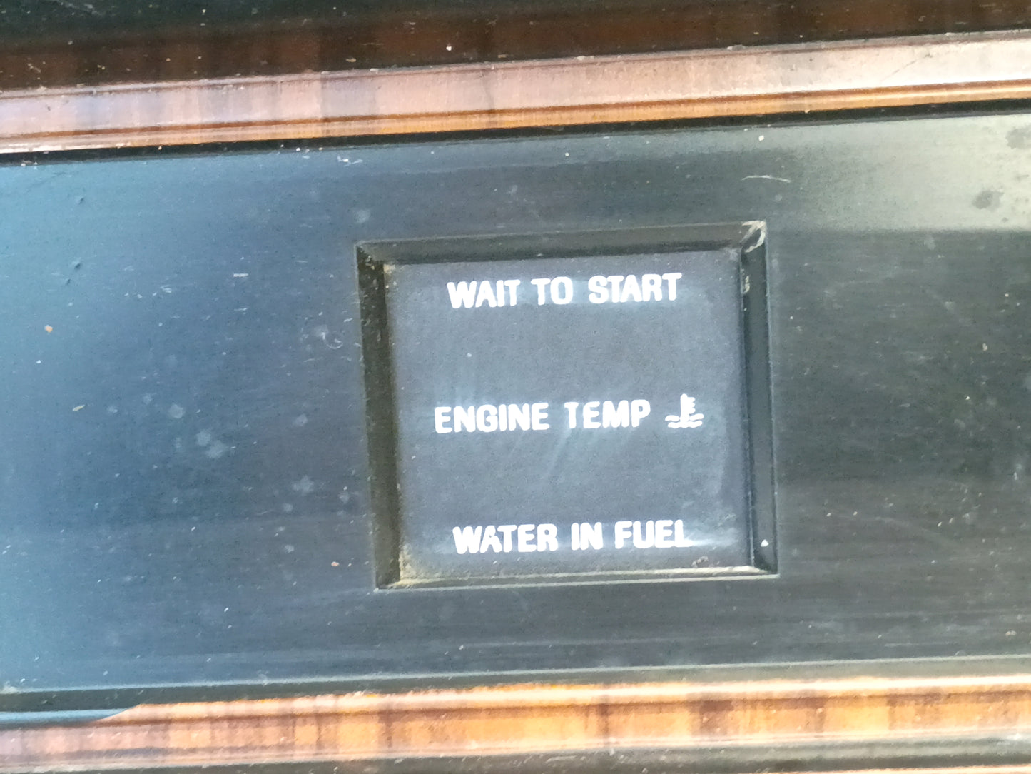 Rose wood gauge cluster bezel with diesel indicator lights, including "Wait to Start," "Engine Temp," and "Water in Fuel," for Ford F250/F350.