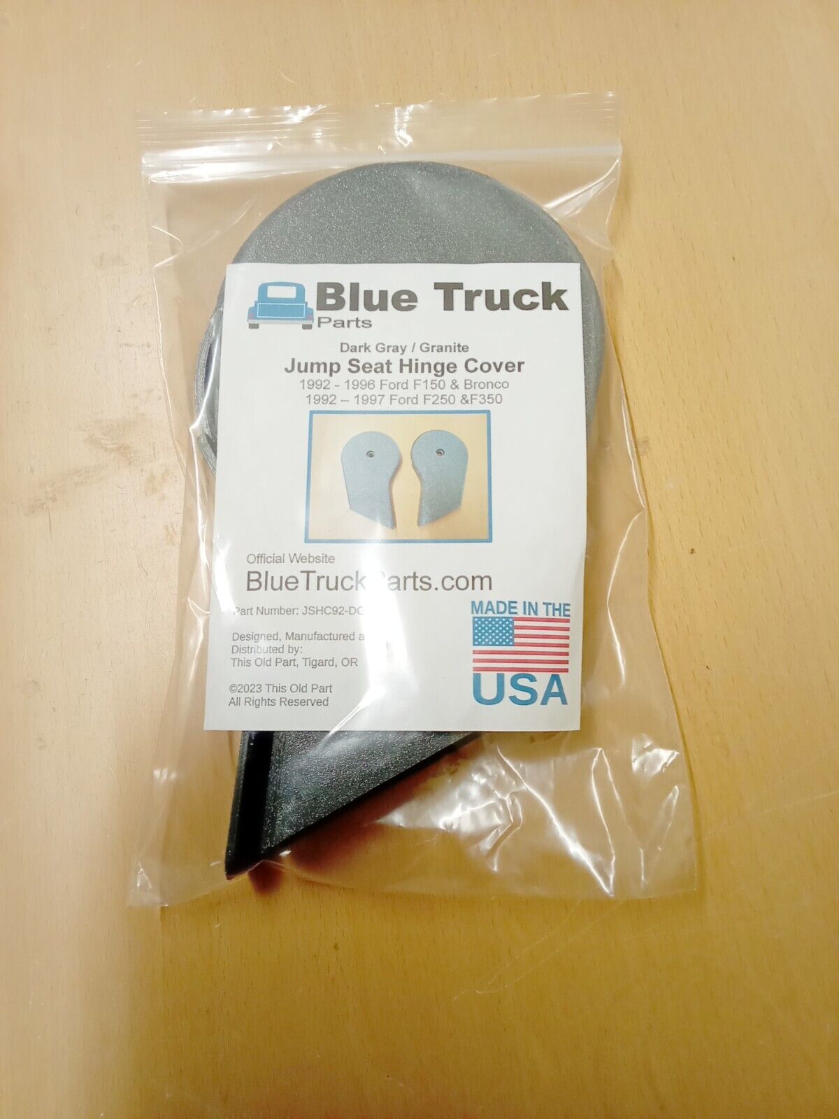Packaged Blue Truck Parts dark gray/granite jump seat hinge covers for 1992-1997 Ford F150, F250, and F350, showing the branded label inside a clear plastic bag.