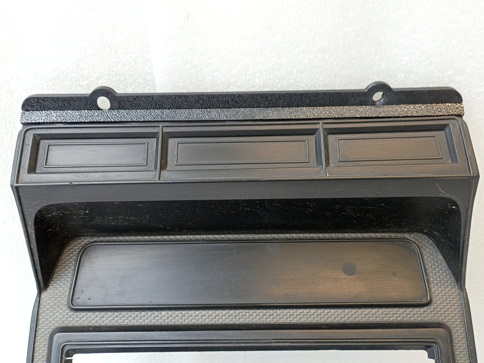 Silver radio and heater bezel for 1980-1986 Ford trucks, featuring a single DIN radio hole and three rectangular slots.