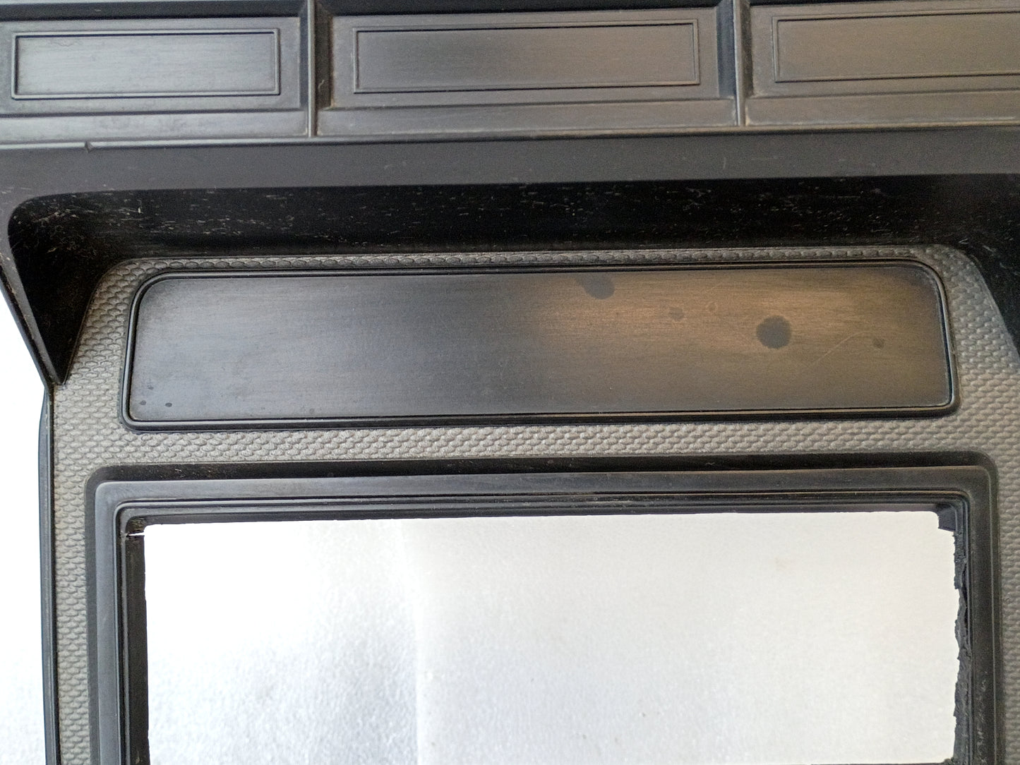 Silver radio and heater bezel for 1980-1986 Ford F-series trucks and Bronco, single din radio hole, textured finish.