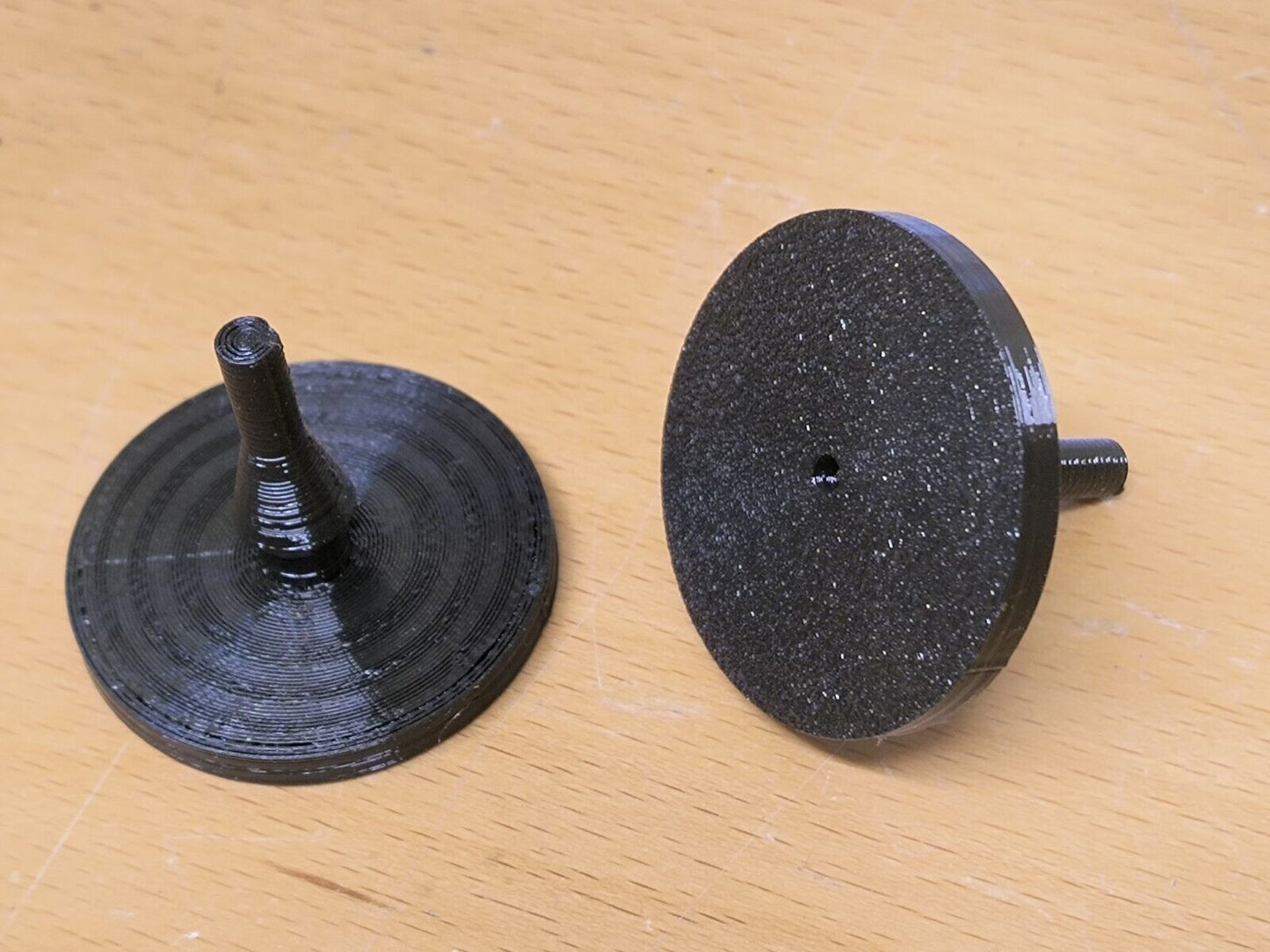 Pair of black circular clutch pedal bumpers for 1980-1991 Ford F-150, F-250, F-350, and Bronco, showing one from the flat textured side and the other from the pin mounting side.