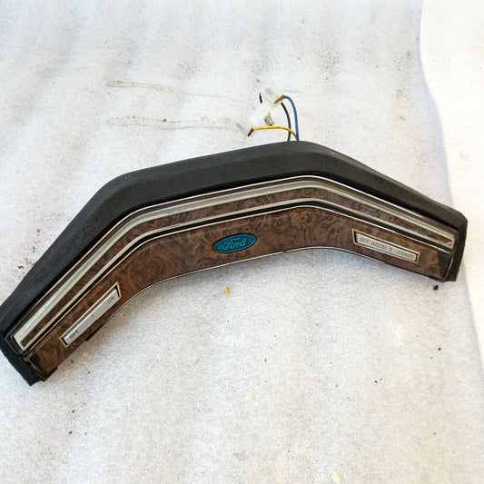 Ford steering wheel horn button with walnut wood grain pattern, angled buttons, and cruise control for 78-79 trucks.