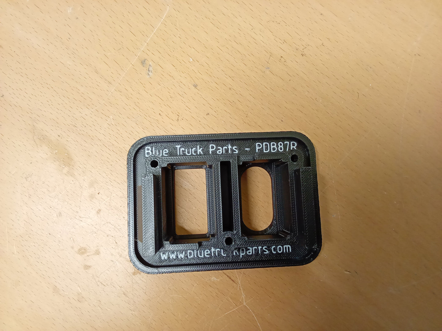 Black power window and lock bezel for 1987-1991 Ford F150-F350 and Bronco, with inlaid lettering and mounting holes.
