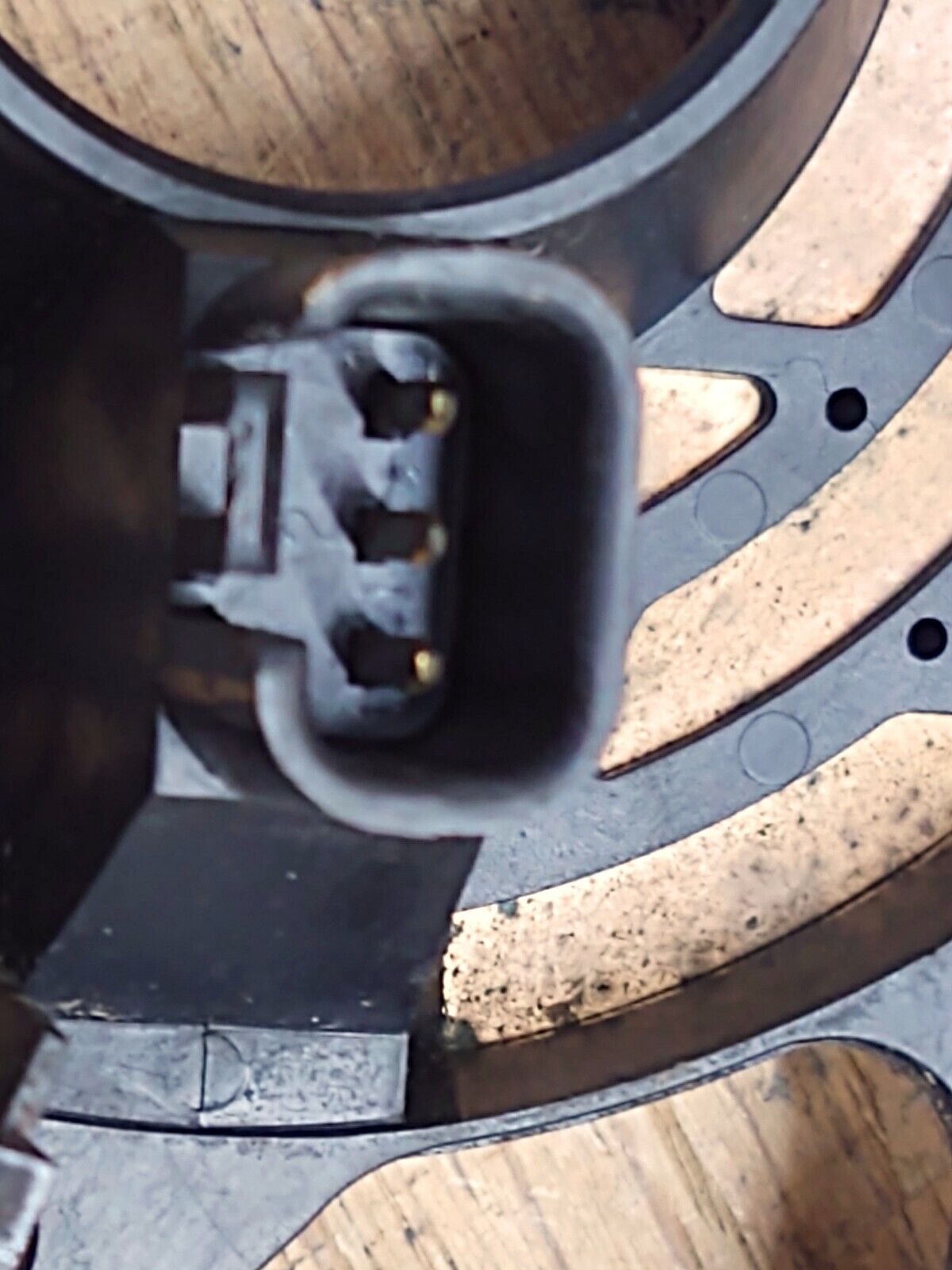 Close-up of the 3-pin electrical connector socket and copper contact tracks on an OEM Ford steering wheel clock spring for 1992-1996 F150, F250, F350, and Bronco trucks.