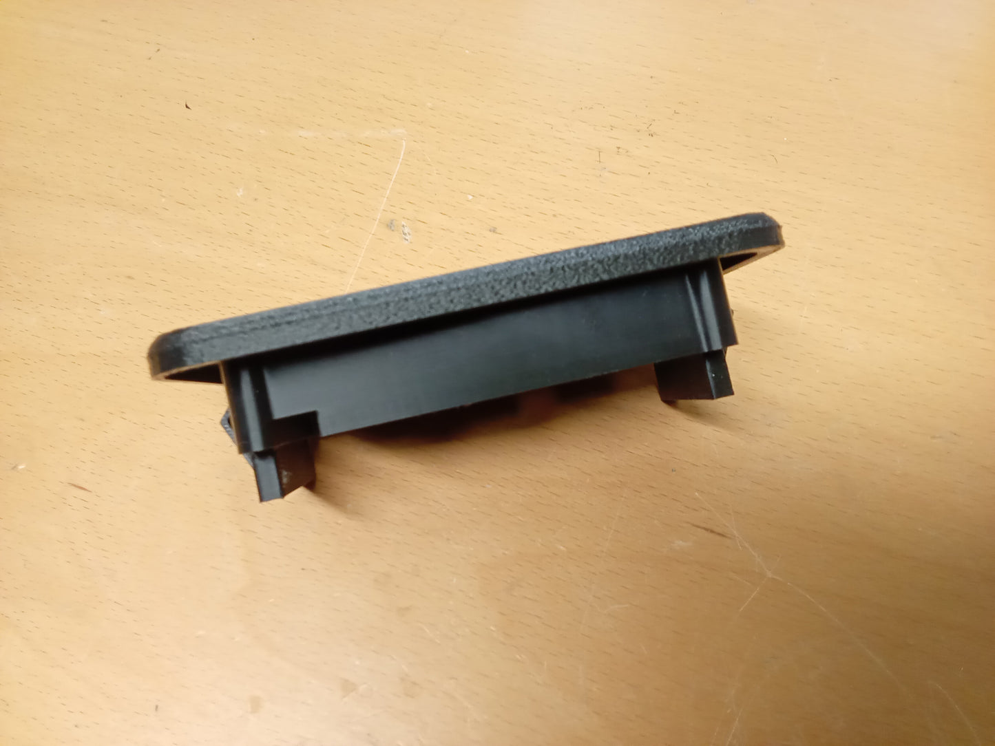 Black power window and lock bezel for 1987-1991 Ford F150, F350, Bronco on a wooden surface.