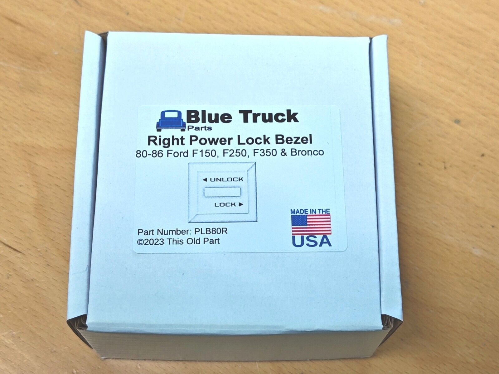 Product box for a Blue Truck Parts Right Power Lock Bezel, part number PLB80R, compatible with 1980-1986 Ford F-150, F-250, F-350, and Bronco.