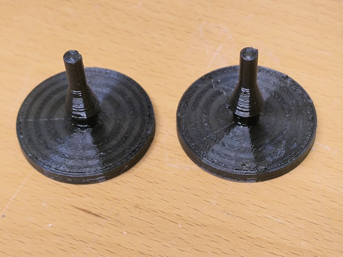 Pair of black rubber clutch pedal bumpers with flat circular bases and central mounting stems, compatible with 1980-1991 Ford F-150, F-250, F-350, and Bronco trucks.