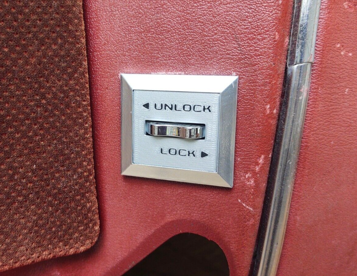 Silver passenger-side power lock bezel with a chrome switch, featuring UNLOCK and LOCK text with directional arrows, for 1980-1986 Ford F-150, F-250, F-350, and Bronco.