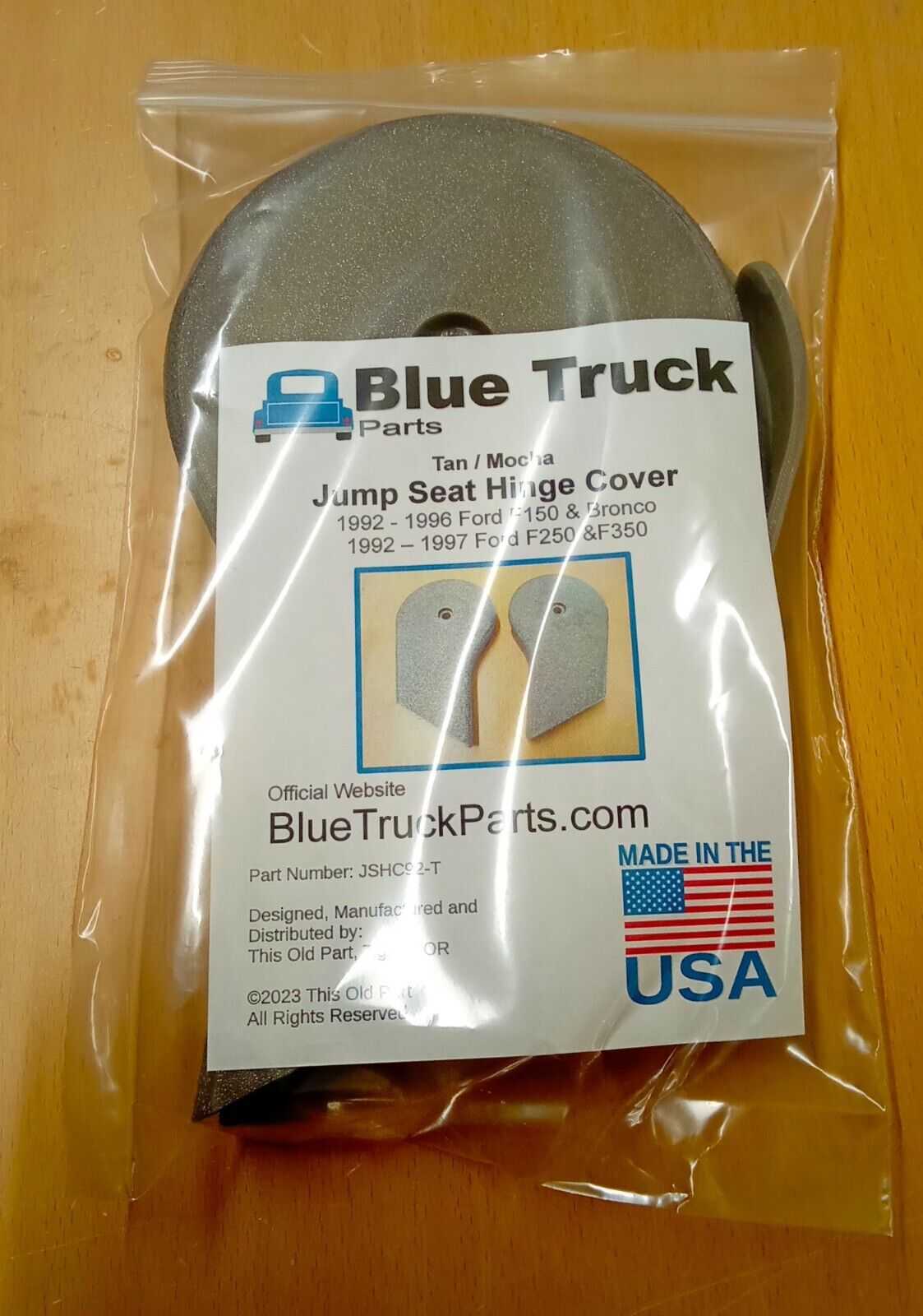 Blue Truck Parts tan or mocha jump seat hinge covers inside a clear plastic package with a labeled insert card for 1992-1997 Ford F-150, F-250, and F-350 trucks.