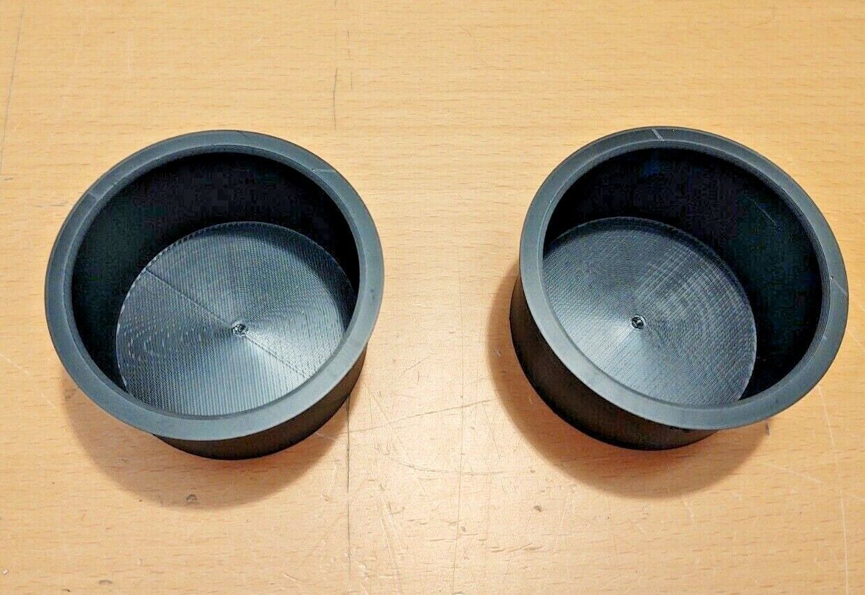 Two black polymer cup holder inserts for 1992-1996 Ford F-150, F-250, F-350, and Bronco center consoles, viewed from above.