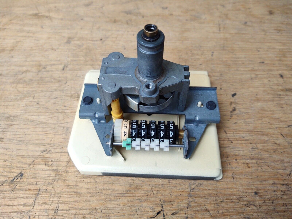 Rear mechanical view of a 1980-1986 Ford Bronco and F-Series speedometer assembly, showing the odometer gear rollers and cable drive input.