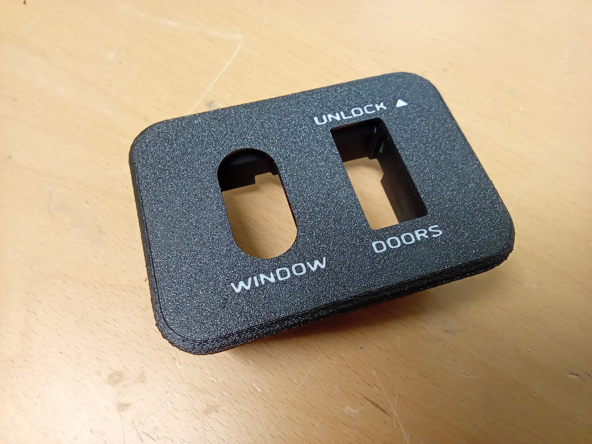 Black power window and lock bezel for 1987-1991 Ford F-Series and Bronco, featuring inlaid lettering "WINDOW" and "DOORS".