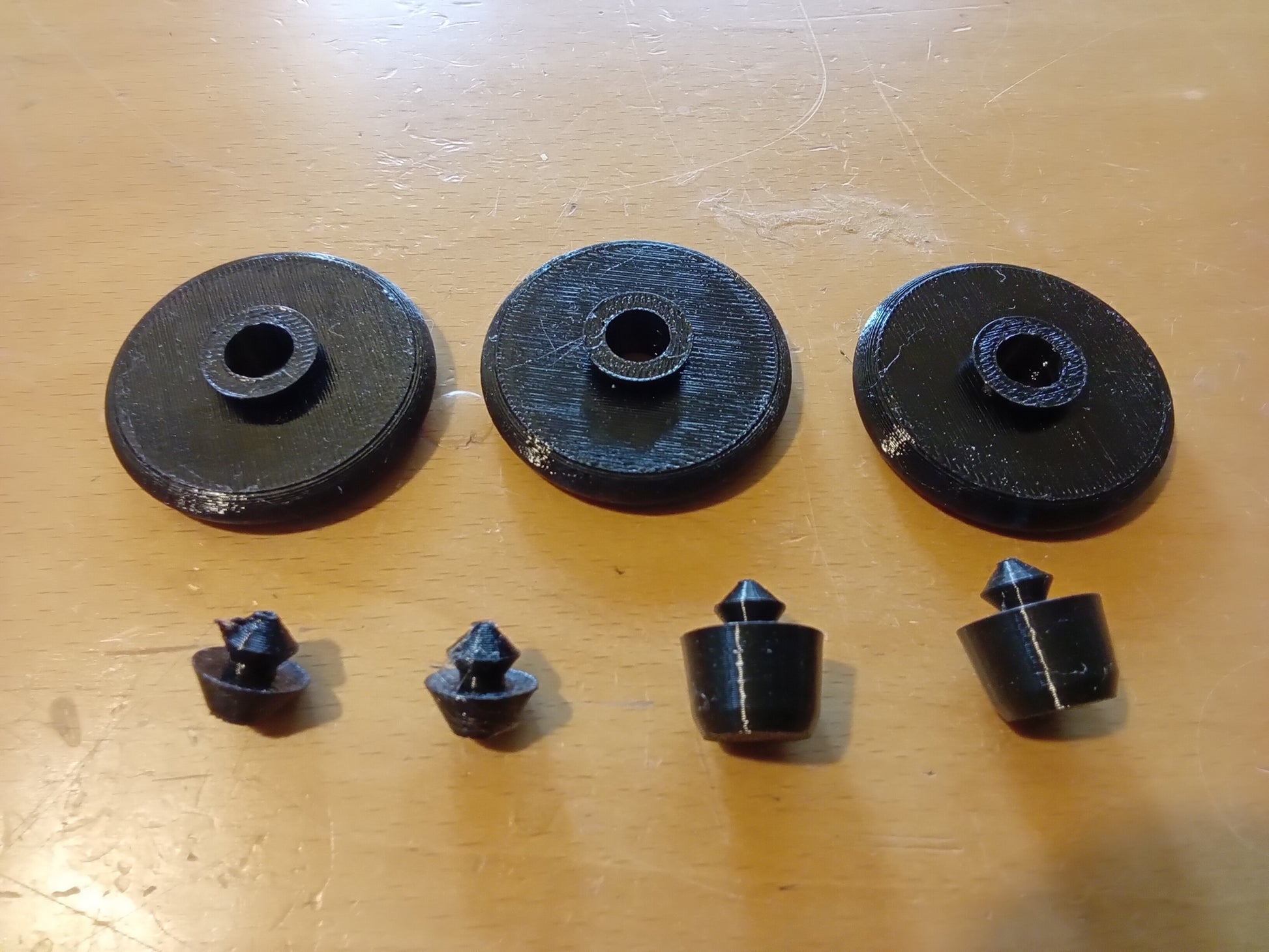 Rubber lid bumper and foot pad set for Ford center consoles, featuring three round bumpers and three tapered foot pads.