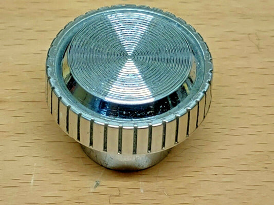 Round chrome headlight switch knob featuring a ribbed outer edge and concentric circular grooves on its top face, compatible with 1980-1991 Ford Bronco and F-Series trucks.